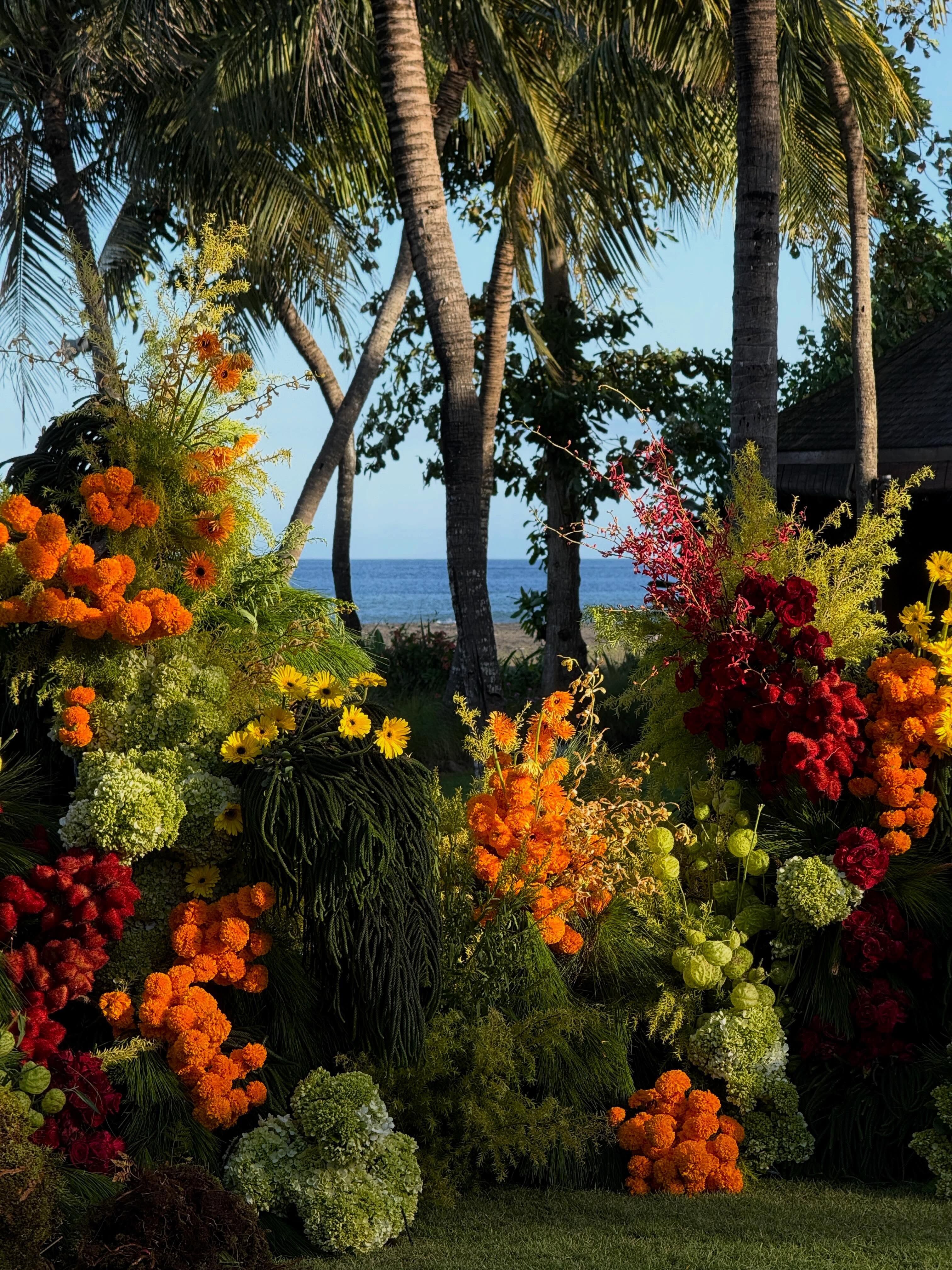 Colorful tropical floral arrangement with palm trees and ocean view